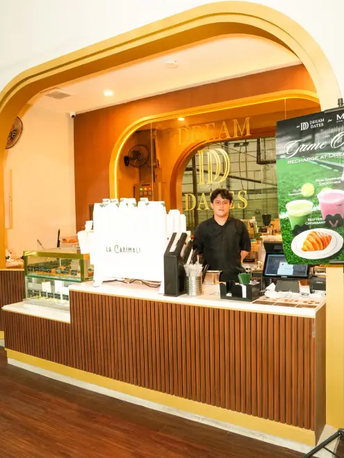 Café counter with pastries and a barista at MOP Arena