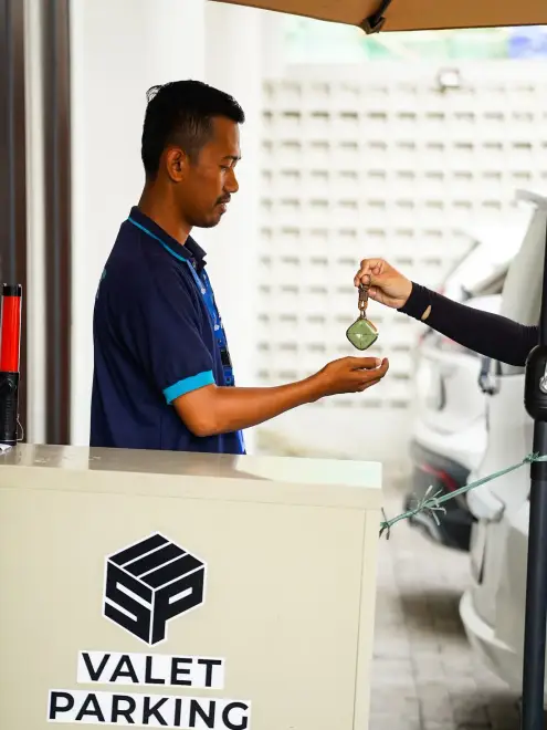 Valet parking attendant handing over a car key
